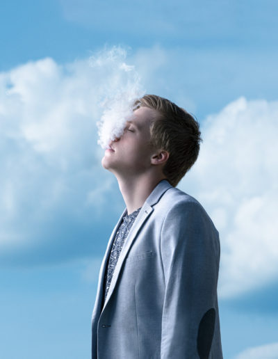 Photographie de Maxence Top sur fond de ciel recrachant de la fumée.