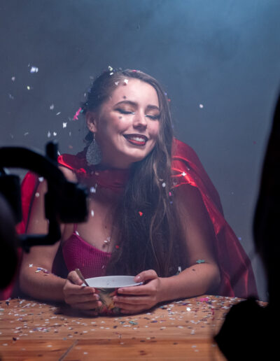 modèle féminin souriante accoudée à une table plein de confettis