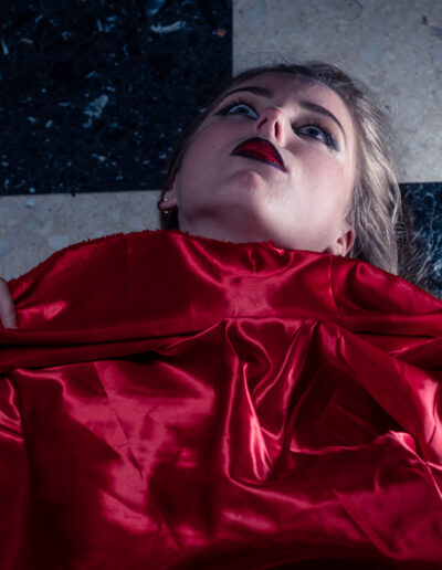 Modèle féminin allongé sur le sol avec un drap rouge