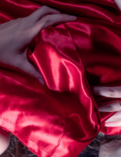 Modèle féminin allongé recouvrant son visage d'un draps rouge