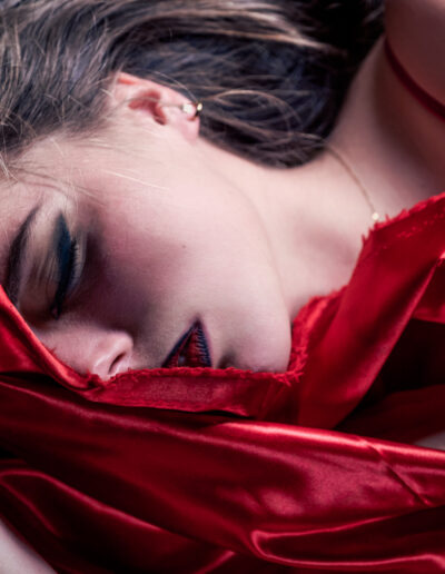 Modèle féminin allongé sur un draps rouge