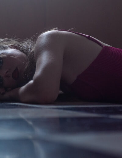 modèle féminin allongée sur le sol dans une ambiance sombre pleine de fumée